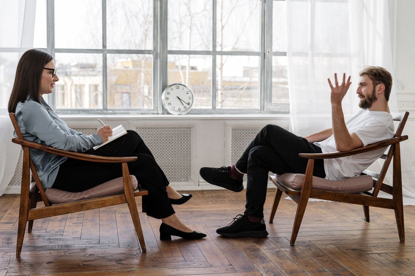 Una psicoterapeuta durante un colloquio con un paziente, in uno studio luminoso